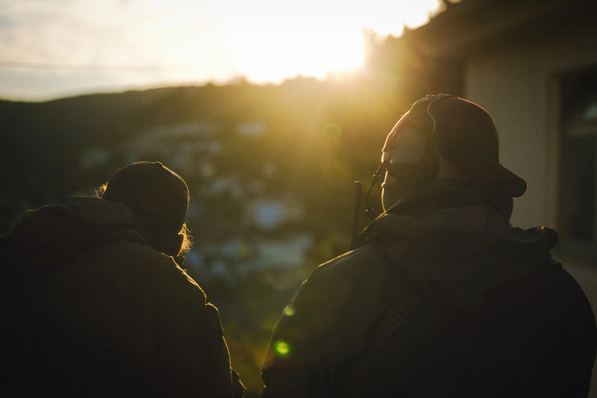 Two operators silhouetted against the setting sun at the end of a shooting day