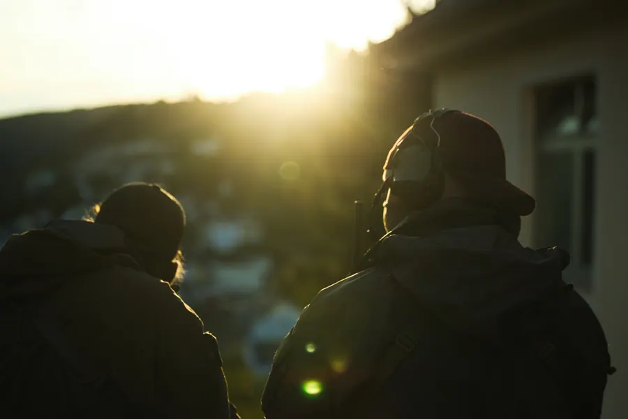 Operators at a building corner in the last of the light