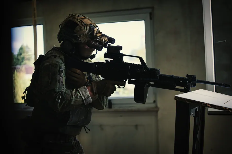 Operator in a window position inside a building, machine gun resting on the frame