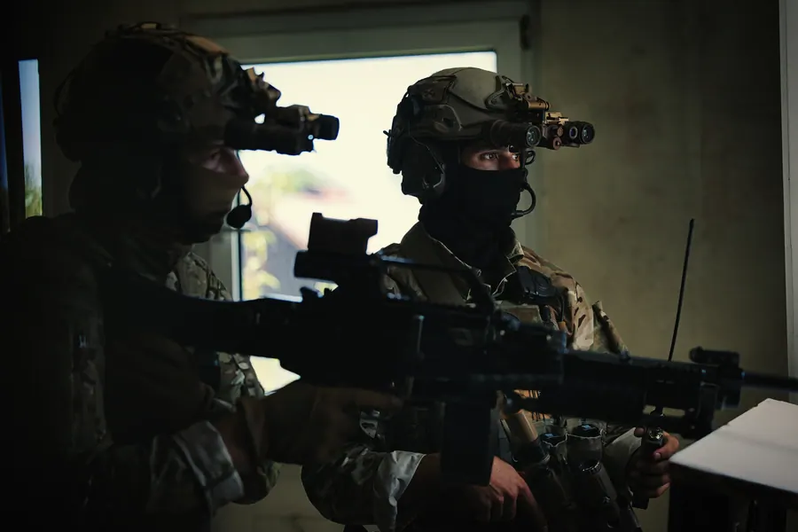 Two operators covering a window position from inside a building