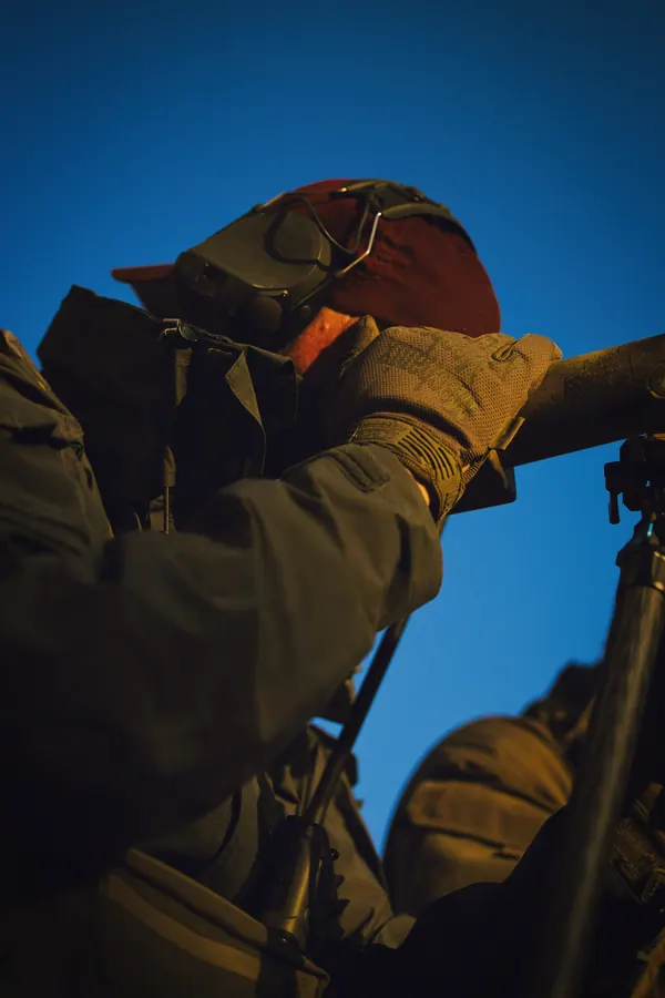 Low angle on a spotter against blue sky, optics raised