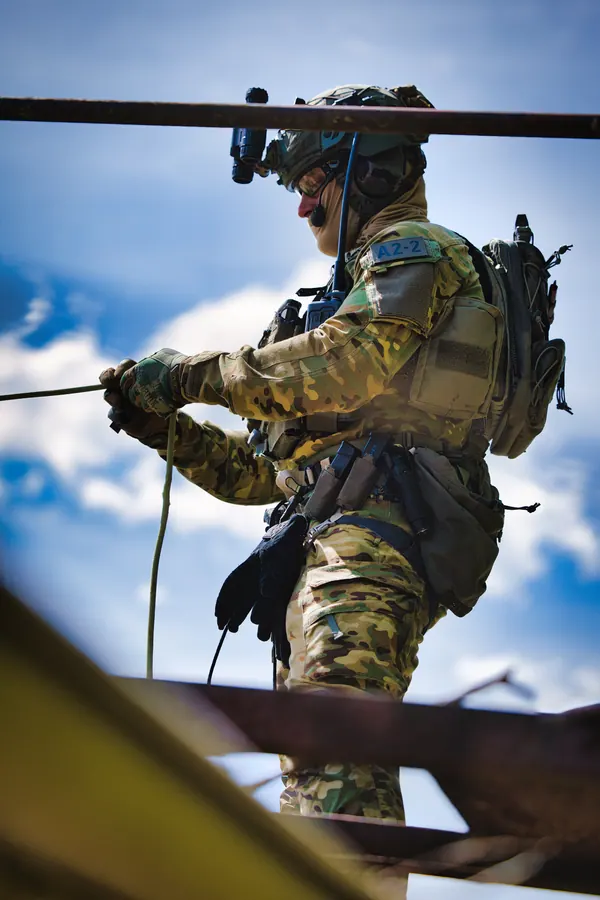 Operator working a rope at height against cloud