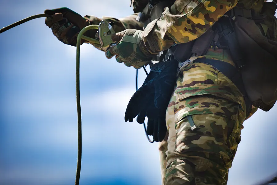 Rope running through a gloved hand at the hip, cloud below