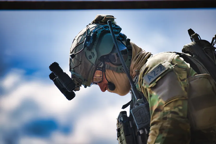 Operator in profile above the cloud line, helmet and comms in daylight