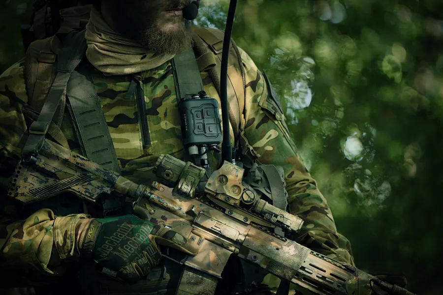 Torso view in MultiCam, rifle carried across the body, magazines on the placard