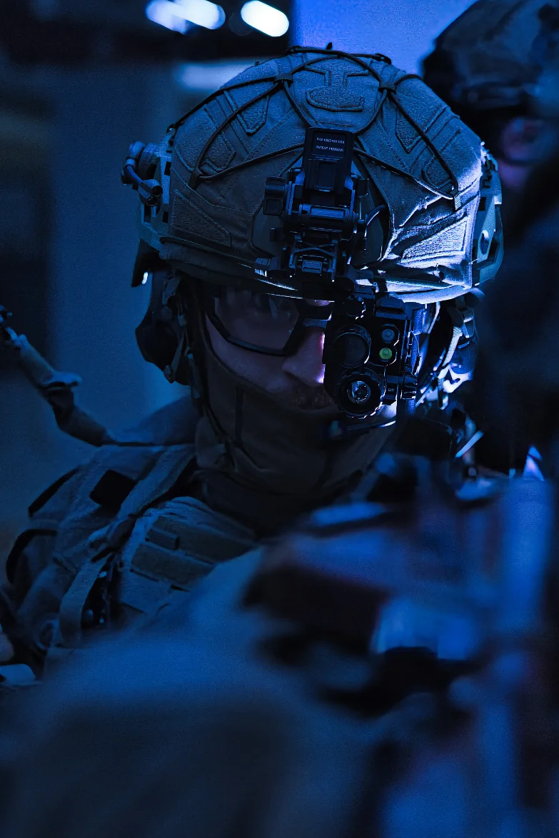 Operator in low light with a helmet mounted night vision device swung down in front of his eye
